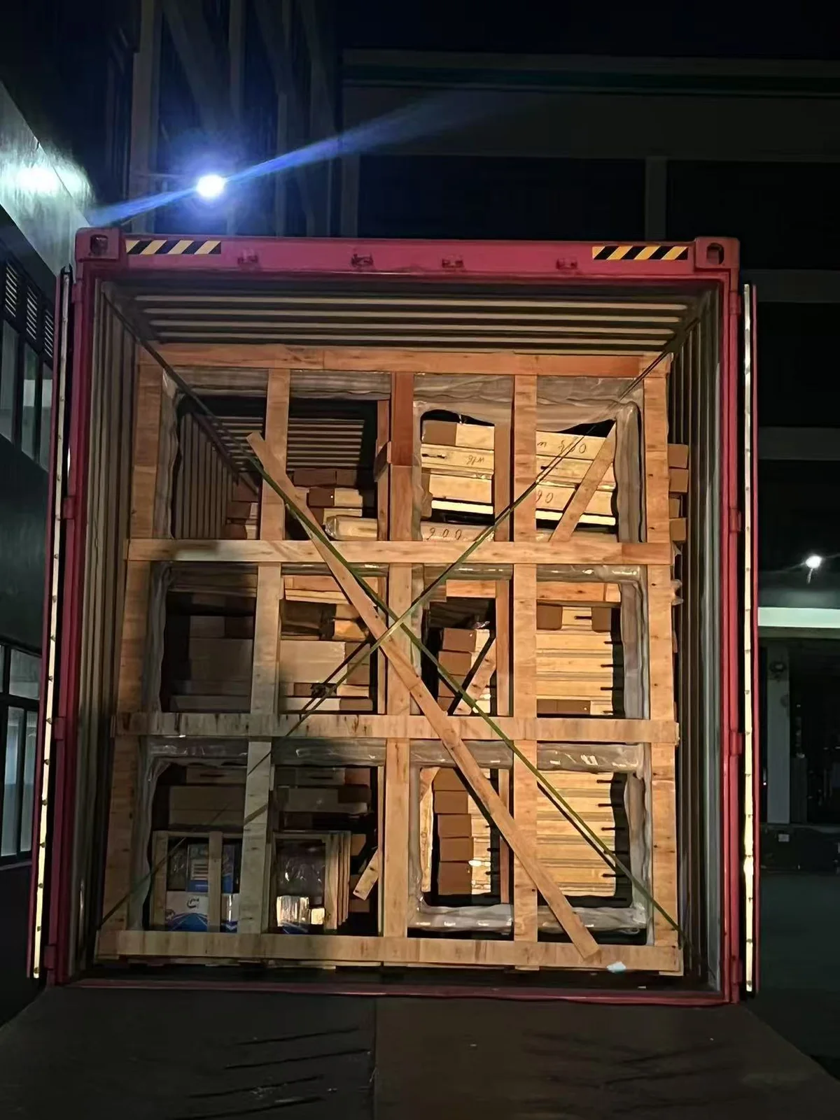 Building materials secured in timber frames inside a loaded container