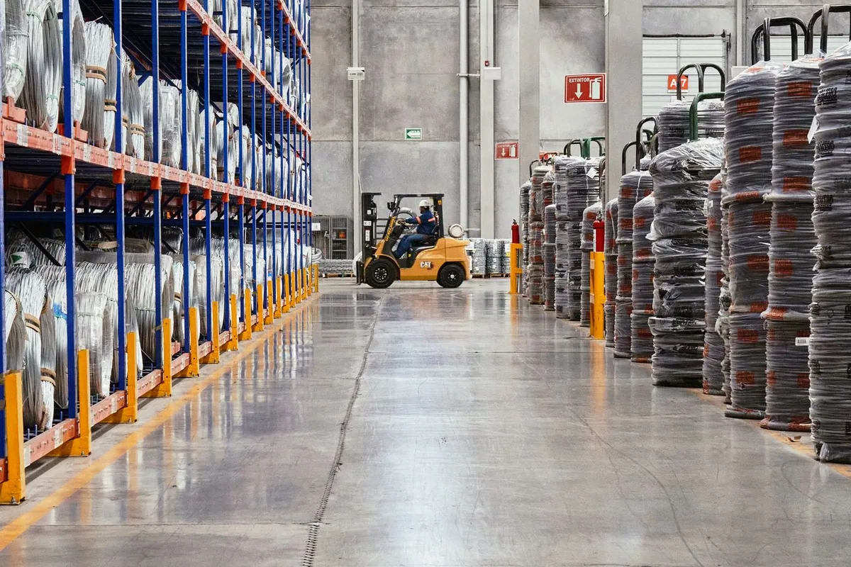Forklift operating between pallet racks in an industrial warehouse